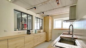 Una cucina moderna con mobili in legno, lavello in acciaio inossidabile e luci a sospensione.