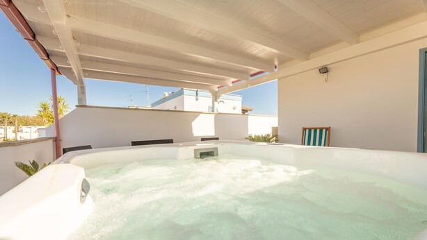 Ein Whirlpool mit weißem Innenraum und freiem Blick zum Himmel.