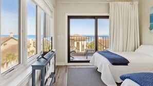 Een hotelkamer met balkon, bed, bureau en televisie.