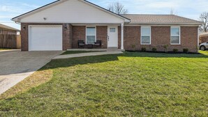 A two-story house with a garage, a front porch, and a well-maintained lawn.