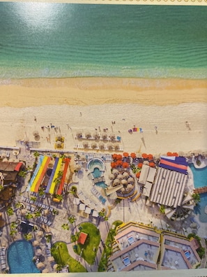 Een resort met een strand, meerdere zwembaden en diverse zitgedeeltes buiten.