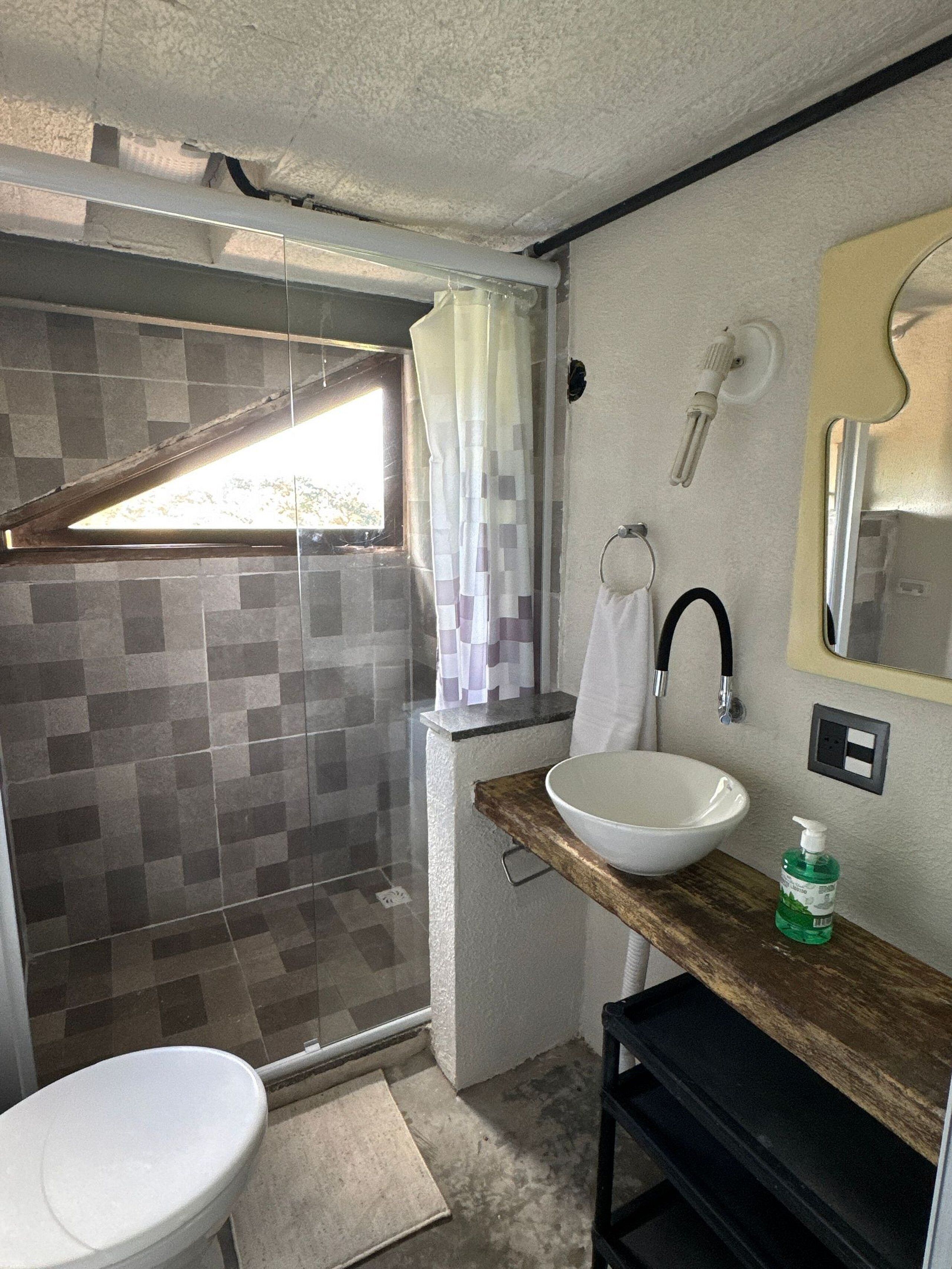 A compact bathroom with a shower, toilet, and sink.