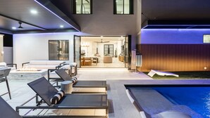 A modern outdoor living area with a pool, lounge chairs, and a fire feature. - Modern Arcadia Family Luxury Compound Htd Pool & Spa, Outdoor Kitchen & Fire Pit (Phoenix)