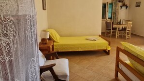 A small, cozy room with a bed, a chair, a table, and a dining area. - Apartments Stiniva Hvar (Hvar)