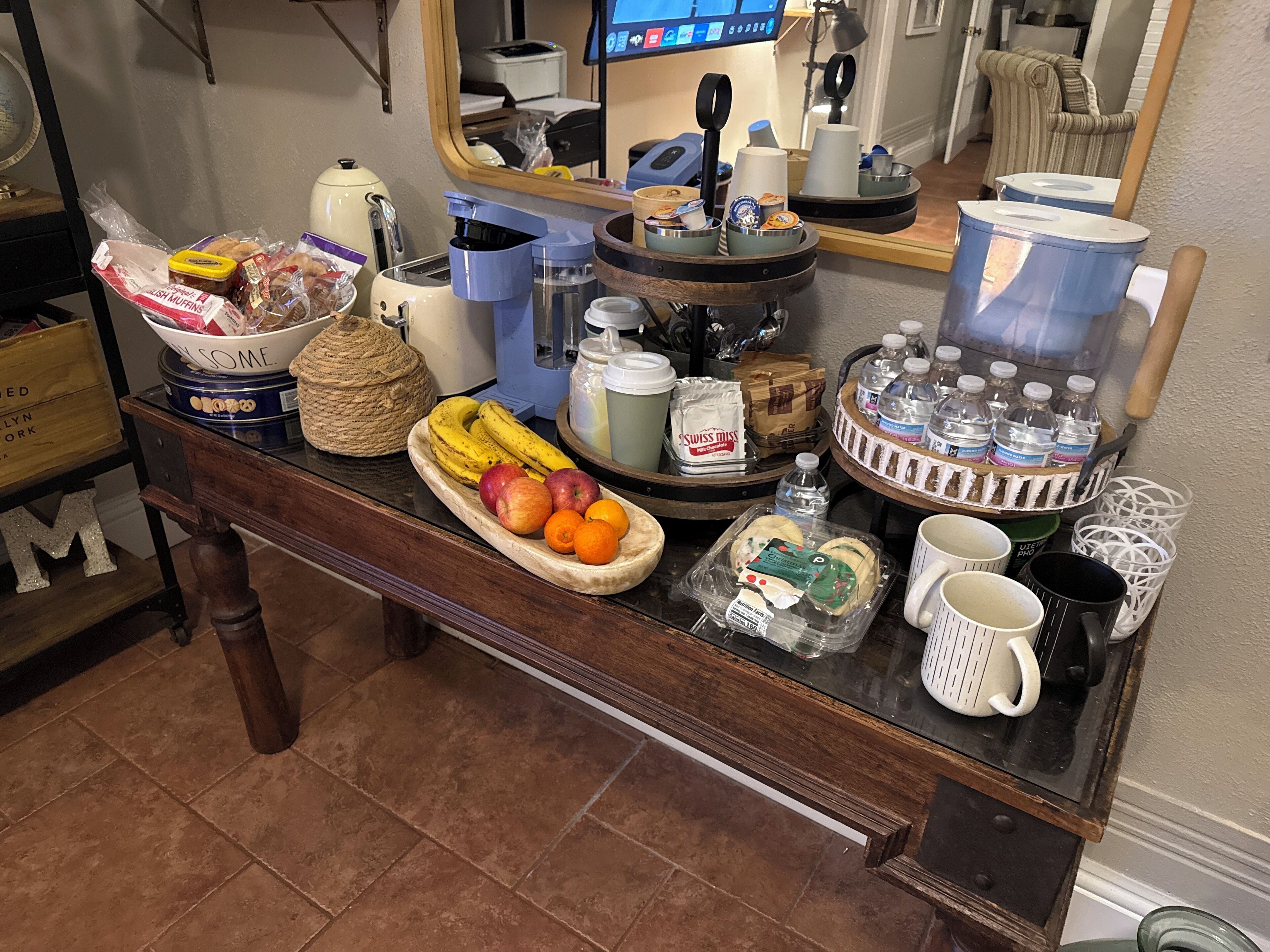 Una barra de desayuno con diferentes opciones de comida, como frutas, bollería y bebidas.