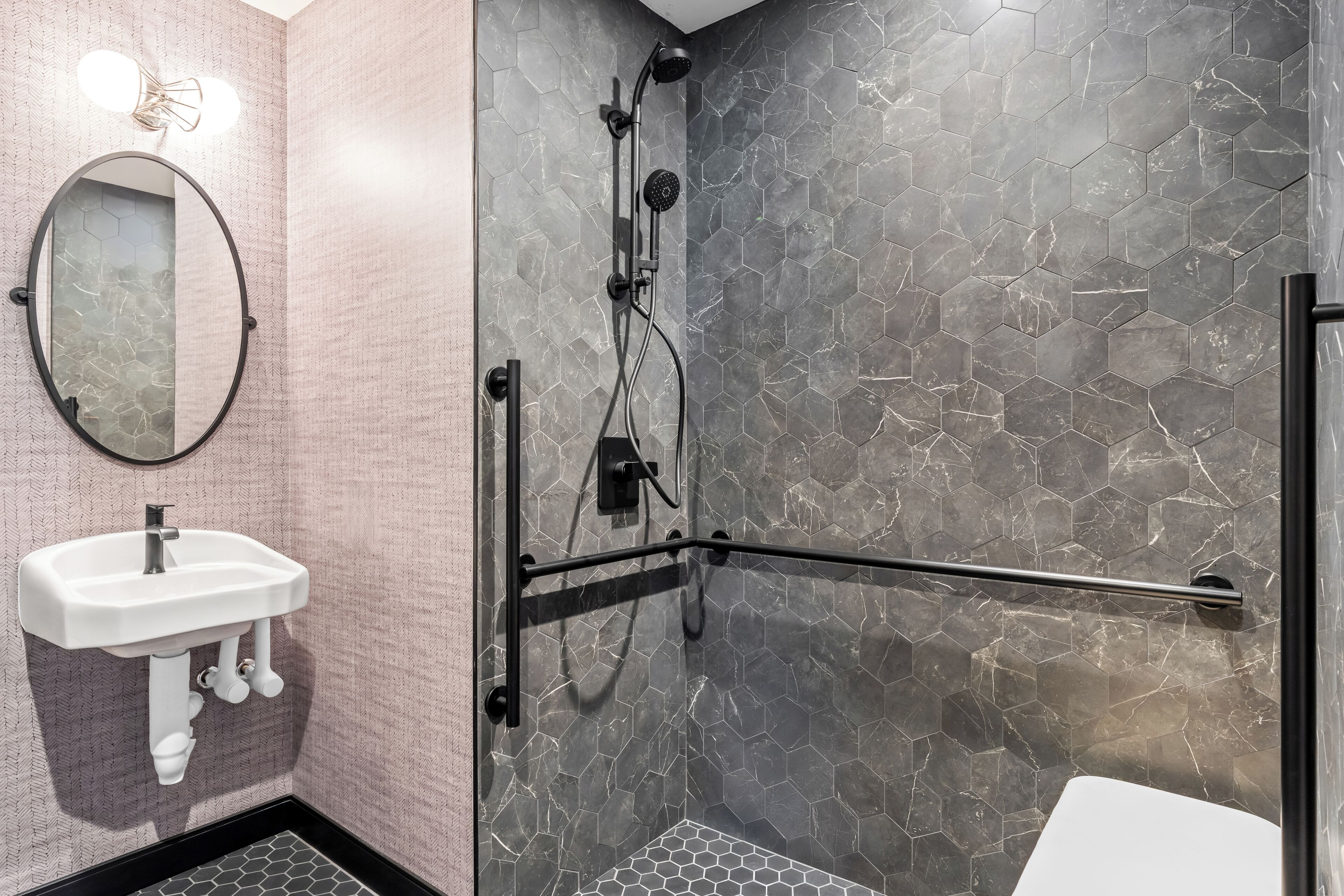 Un baño con ducha, lavabo y espejo.