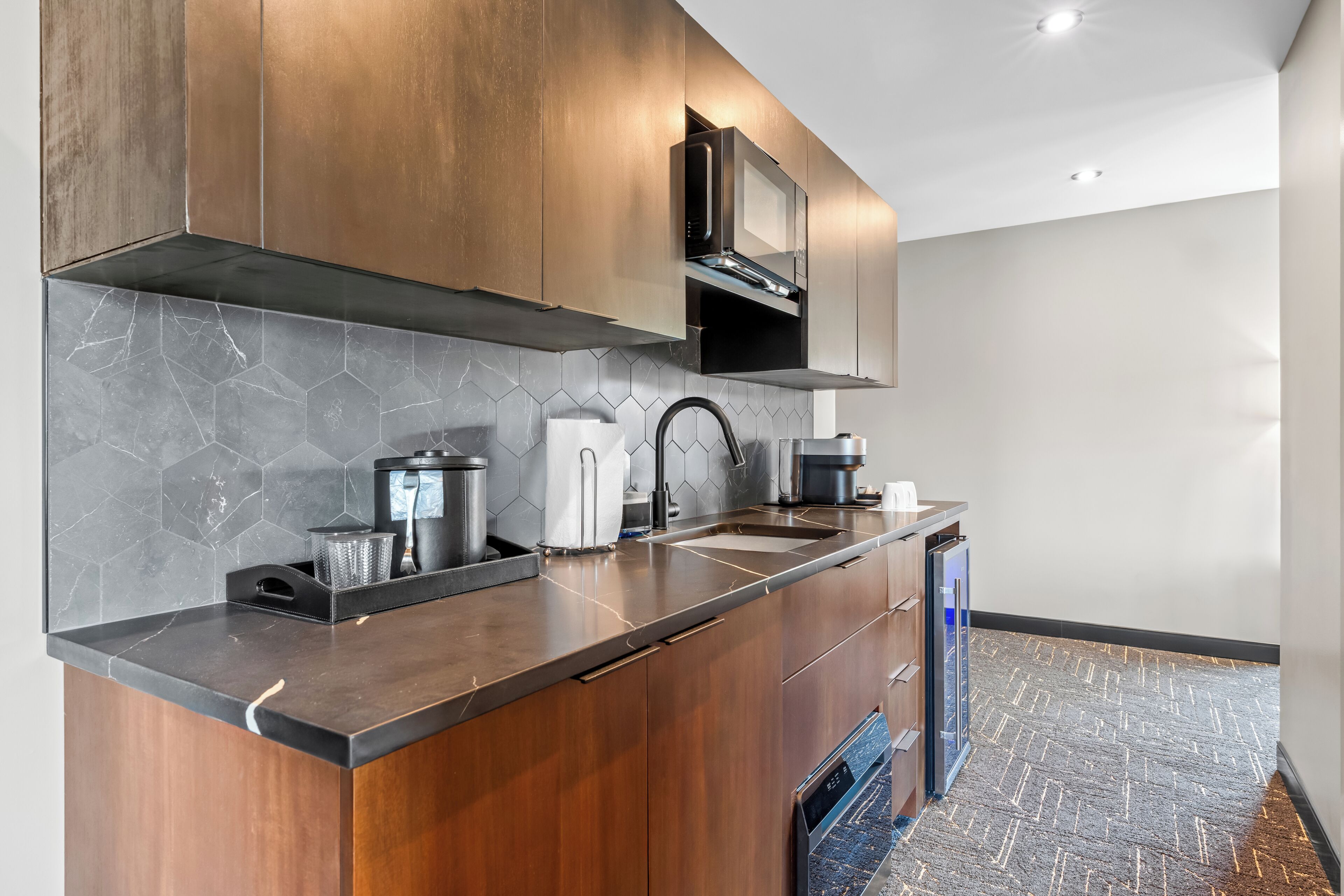 A modern kitchen with a microwave, sink, and dishwasher.
