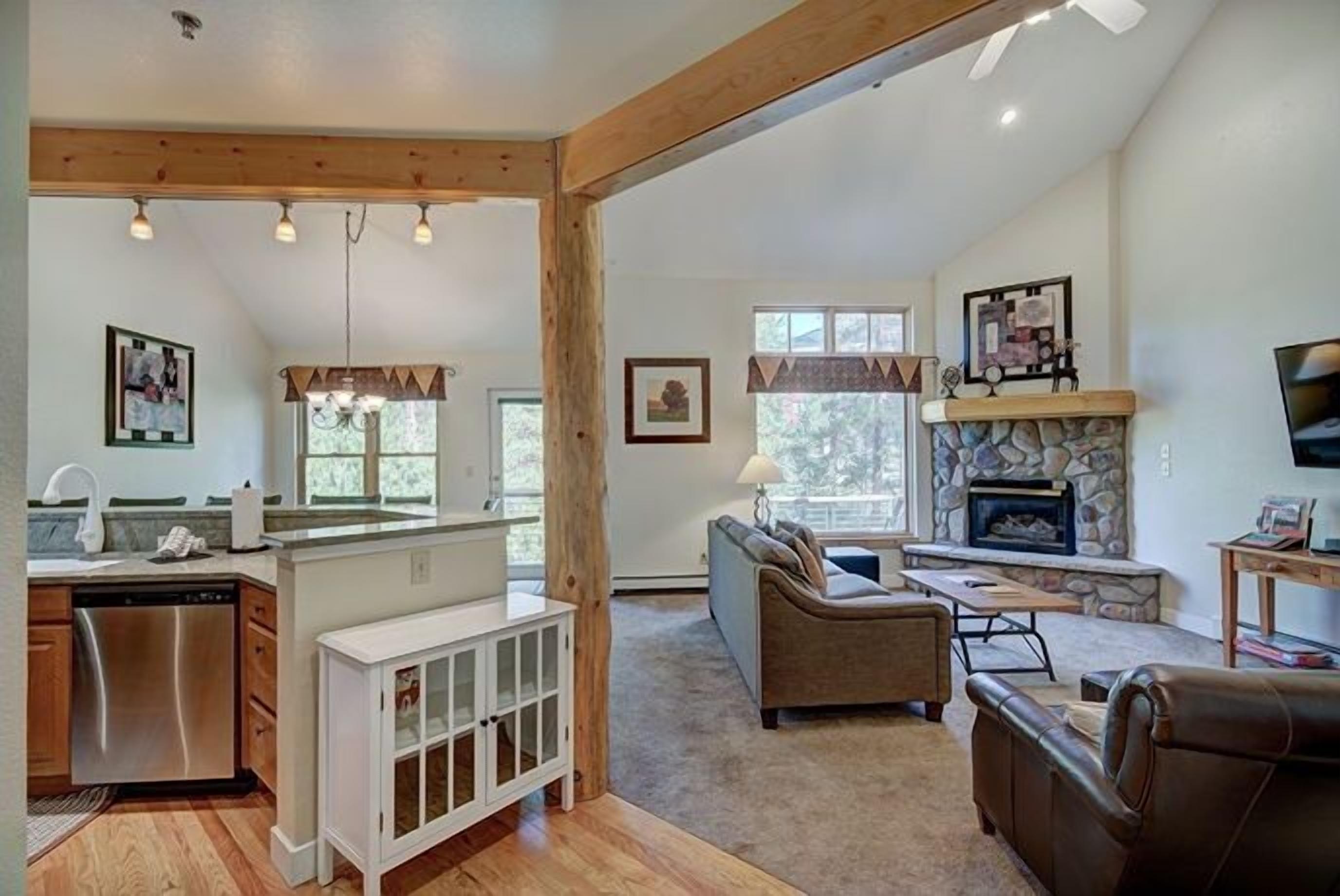 A spacious living area with a fireplace, a sofa, and a dining area.