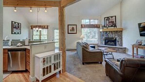 A spacious living area with a fireplace, a sofa, and a dining area. - Premier Keystone 3BR Townhome w/ Resort Access (Keystone)