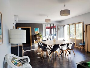 A modern dining area with a round table, black and white chairs, and a large window with a view.