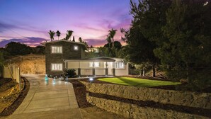 A modern two-story house with a stone facade, a well-maintained lawn, and a driveway leading to the entrance. - King Bed, 6 Parking, 6 Beds, Big Yard (Spring Valley)