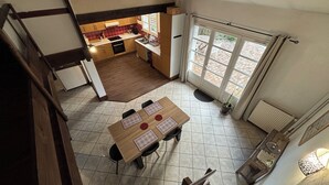 A spacious kitchen with a dining area, a staircase, and a view of the outside. - T3 duplex house, atypical, with wooded garden, very large terrace and parking space (Toulouse)