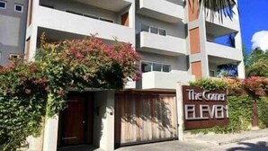 A multi-story building with balconies, a gated entrance, and a sign reading "The Cove". - Modern apartment with shared pool and generator (2-2B) (Simpson Bay)