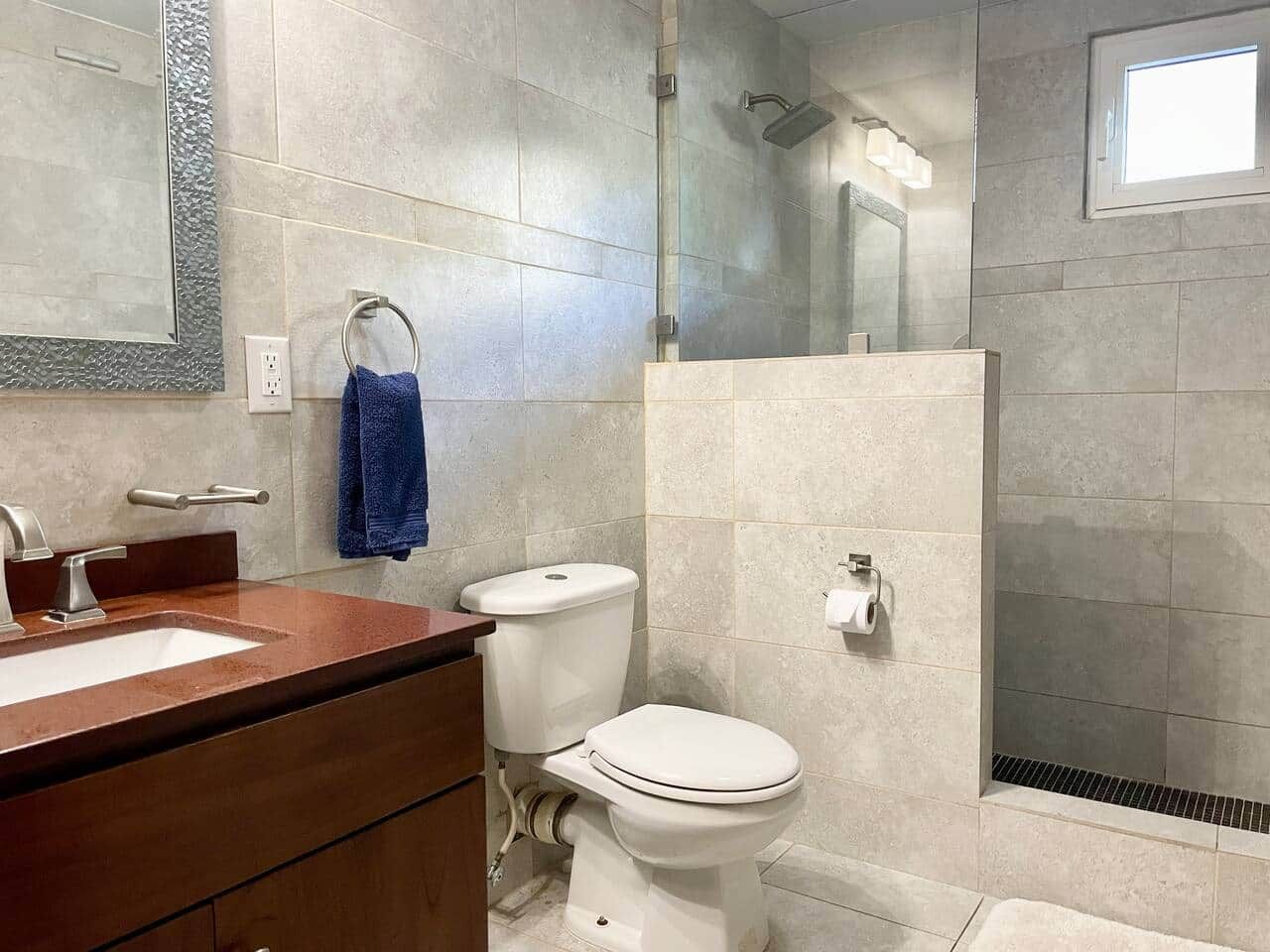 A bathroom with a shower, toilet, and sink.