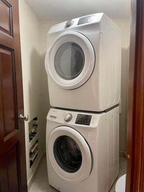 A compact laundry room with two stacked front-loading washing machines.