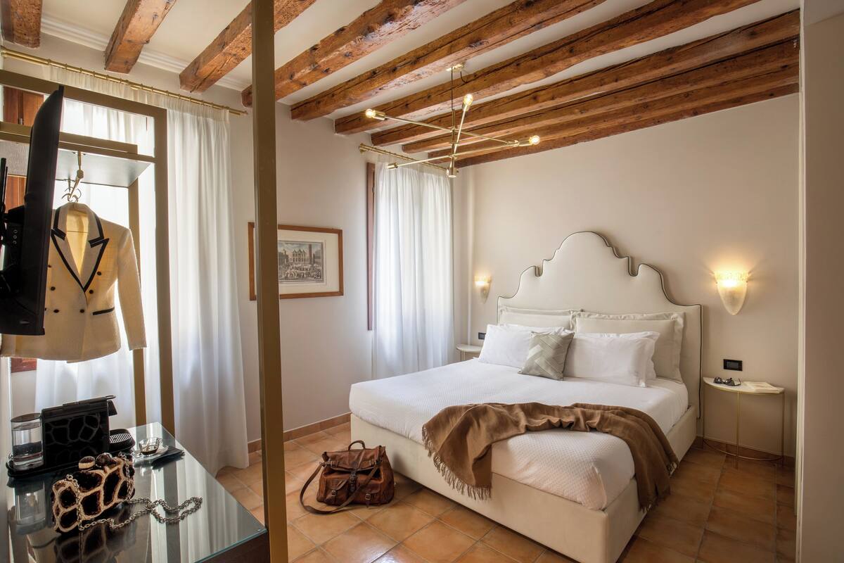 A bedroom with a bed, bedside table, and a hanging coat rack.