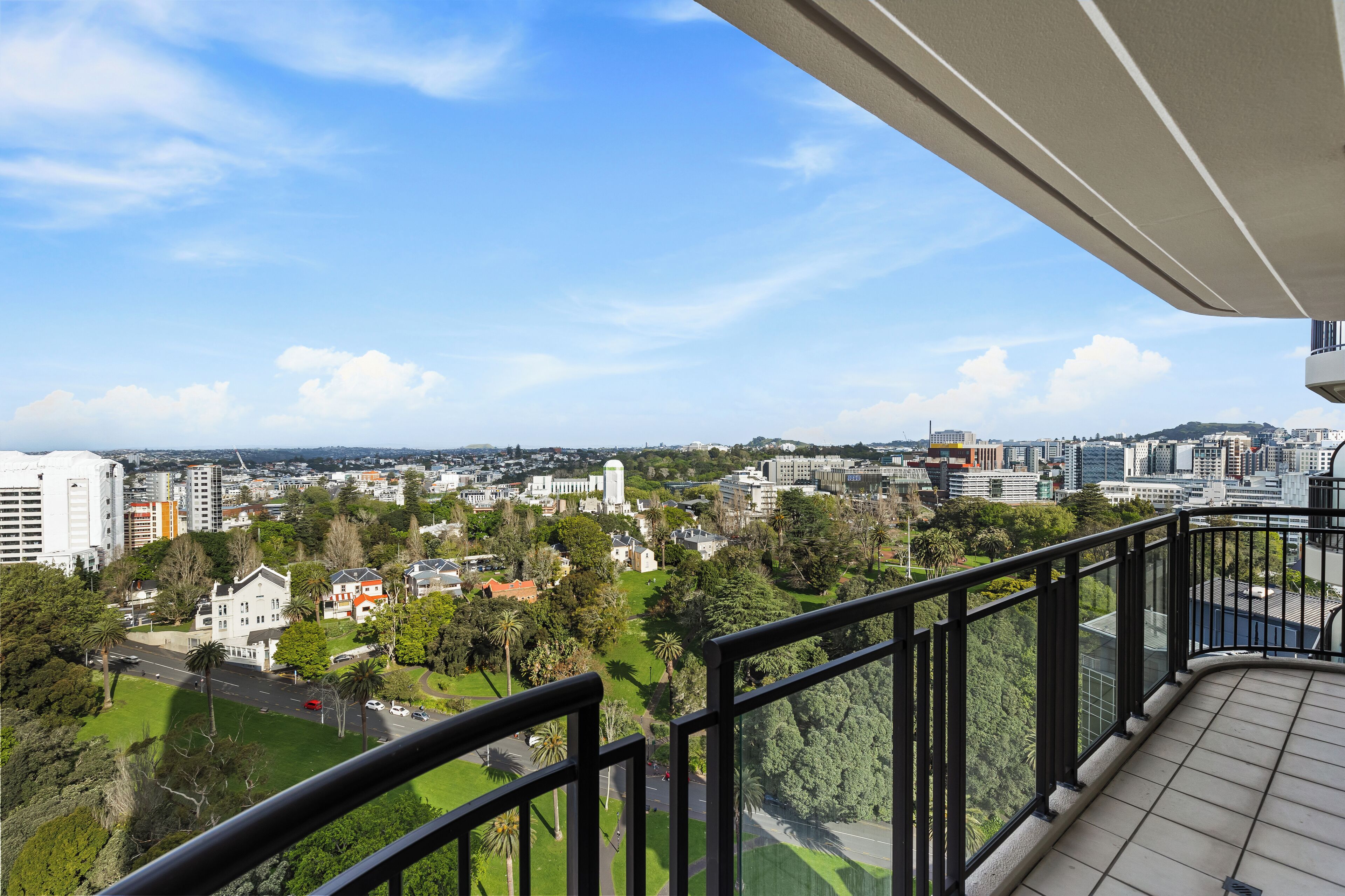 Un balcone con vista sulla città, tra edifici e spazi verdi.
