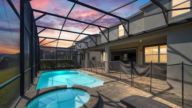 A rooftop pool with a glass enclosure, two hot tubs, and outdoor seating. - Stunning Kissimmee Home  Private Pool Near Disney Parks (Kissimmee)