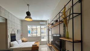 Ein modernes Wohnzimmer mit einem Bett, einem Fernseher und einem Couchtisch aus Holz.