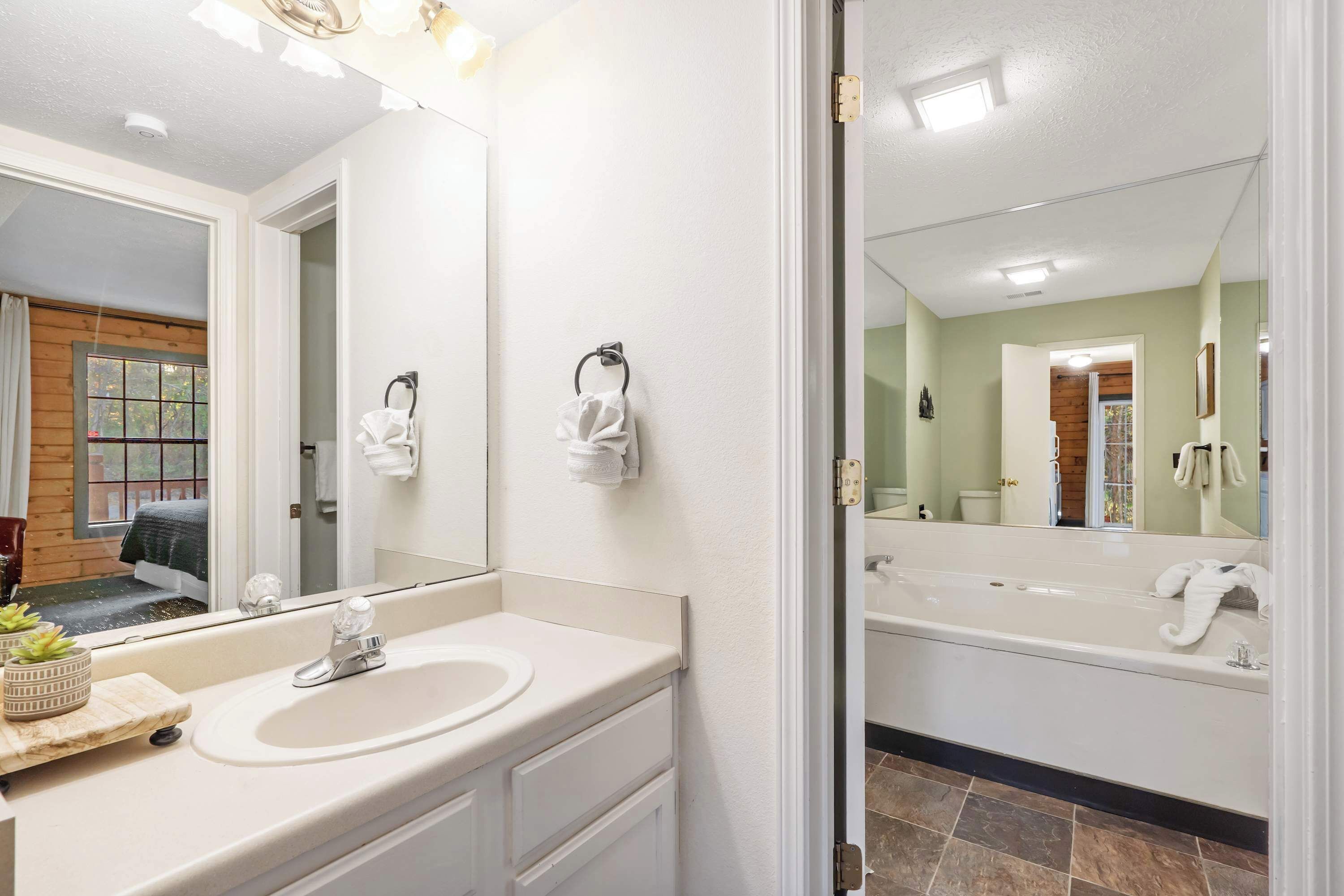 Un baño moderno con un espejo grande, un lavabo y una bañera.