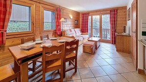 Eine Holzhütte mit Essbereich, einer Couch und einer Küche.
