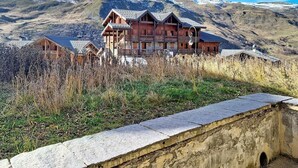 Ein Chalet mit mehreren Balkonen vor einer Bergkulisse.
