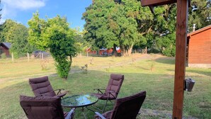 An outdoor seating area with four brown chairs and a small round table. - Beautiful Family Cabin in Pucón (Pucon)