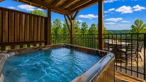 A hot tub under a wooden pergola with a view of trees and a clear sky. - Heated Pool (seasonal), Hot Tub, Game Room, & Mountain Views – Sleeps 12 (Sevierville)