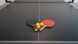 Ein Tischtennis-Tisch mit zwei Schlägern und zwei Bällen.