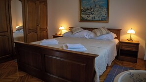 Ein Hotelzimmer mit einem hölzernen Bett, zwei Nachttischen mit Lampen, einem Bild an der Wand und einem Holzboden.