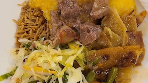 A plate of food with various dishes including meat, potatoes, and vegetables. - 6Cape Guest House Kawanda  (Kampala)