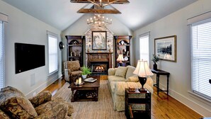 A spacious living room with a fireplace, comfortable seating, and a large flat-screen TV.