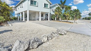 Une maison à deux étages avec un patio couvert et une allée.