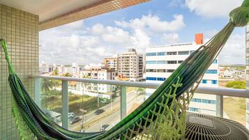 Una hamaca en un balcón con vista a la ciudad.