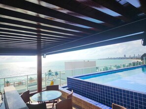A rooftop pool with a view of the ocean and a city skyline. - Your Complete Stay With a Rooftop Pool, 40m From the Beach in Cabedelo Cmzs (Cabedelo)