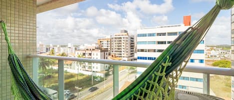 Una hamaca en un balcón con vista a la ciudad.