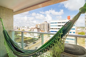 A hammock on a balcony with a city view. - Your Complete Stay With a Rooftop Pool, 40m From the Beach in Cabedelo Cmzs (Cabedelo)