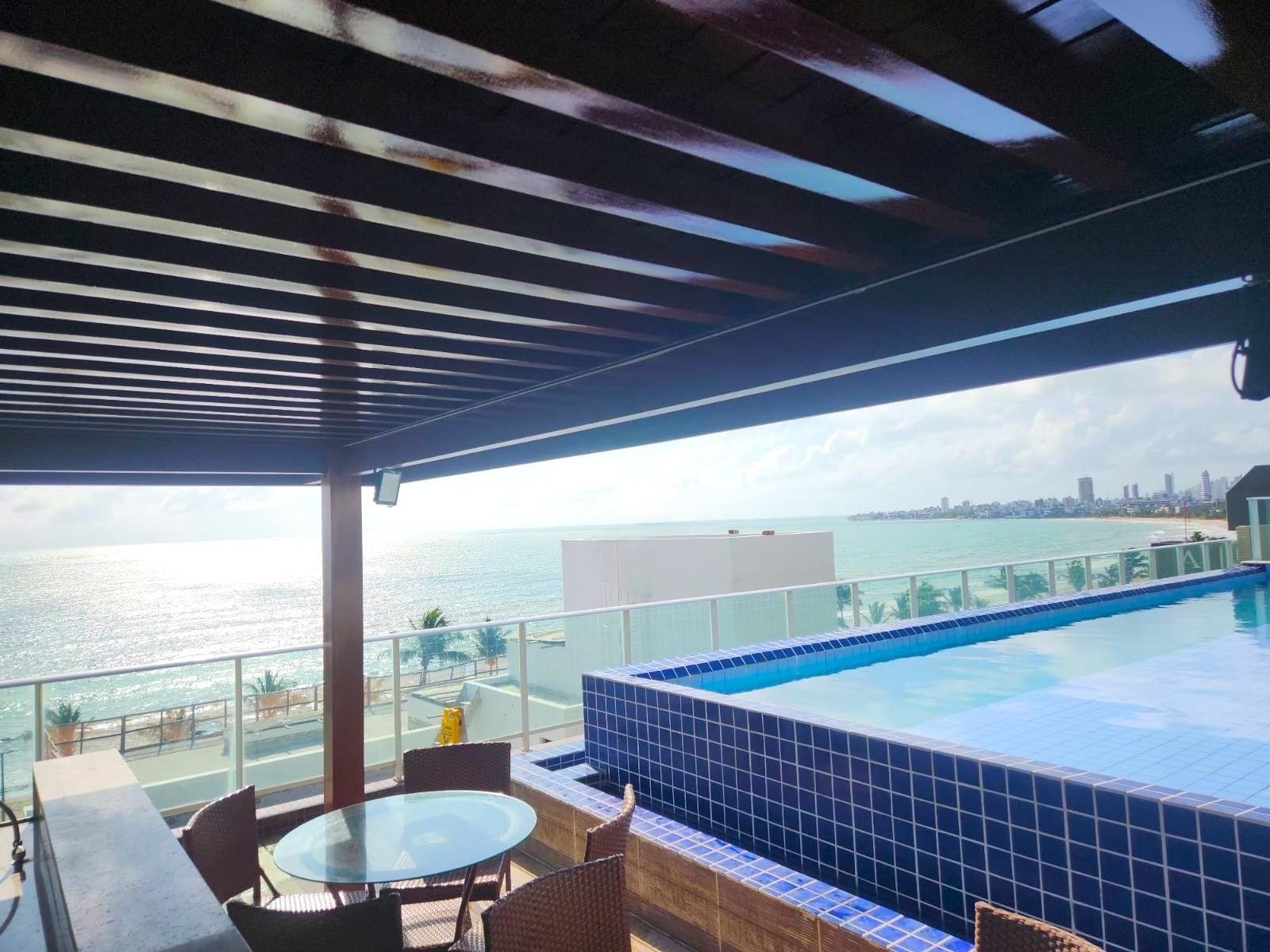 Piscina no terraço com vista para o oceano e para o horizonte da cidade.