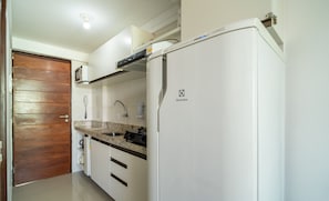 A kitchen with white cabinets, a granite countertop, a microwave, and a refrigerator with the Electrolux logo. - Your Complete Stay With a Rooftop Pool, 40m From the Beach in Cabedelo Cmzs (Cabedelo)