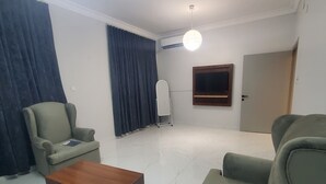 A modern living room with a sofa, armchair, and a coffee table. - Rehana Hotel (Khamis Mushait)