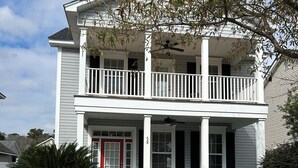 A two-story house with a front porch, a red door, and a mailbox. - Pond View near Old Town Bluffton (Bluffton)