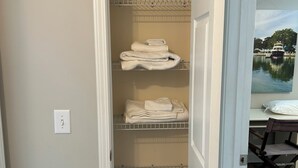 A walk-in closet with shelves for folded towels and a thermostat on the wall. - Pond View near Old Town Bluffton (Bluffton)