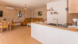 Ett kompakt bostadsutrymme med ett köksområde, en soffgrupp och ett matbord.