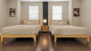A bedroom with two beds, wooden flooring, and artwork on the walls. - HUGE 3BD 2.5BA • 2,118 Sq Ft • Sleeps 11 • KING BD (San Gabriel)