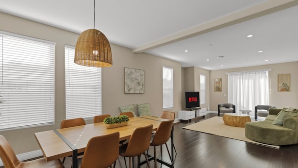 A modern living room with a dining area, a sofa, a TV, and artwork on the walls. - HUGE 3BD 2.5BA • 2,118 Sq Ft • Sleeps 11 • KING BD (San Gabriel)