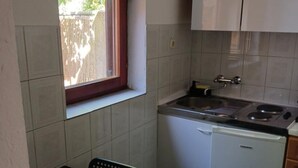 A compact kitchen with a window, a sink, a stove, and a dishwasher. - Apartmani Green Oasis - One Bedroom Apartment with Terrace and Sea View (Vis)