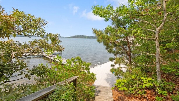 A wooden staircase leading to a dock by a lake, surrounded by trees and vegetation. - Water Views, Dog Friendly, Fire Pit in Brewster (Brewster)