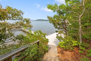 A wooden staircase leading to a dock by a lake, surrounded by trees and vegetation. - Water Views, Dog Friendly, Fire Pit in Brewster (Brewster)