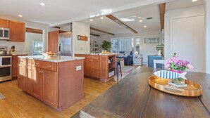 A spacious kitchen with wooden cabinets, a large island, and a dining area with a wooden table. - Water Views, Dog Friendly, Fire Pit in Brewster (Brewster)