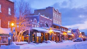 A historic downtown street with brick buildings, snow-covered sidewalks, and illuminated storefronts. - 4 BR / 3.5 BA Home Near Downtown Truckee & Skiing! (Truckee)